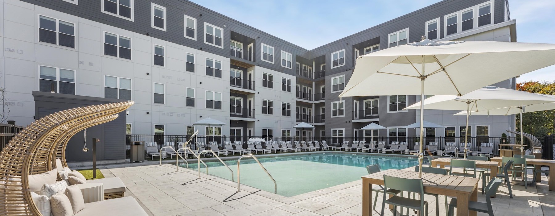 a pool with tables, chairs and umbrellas