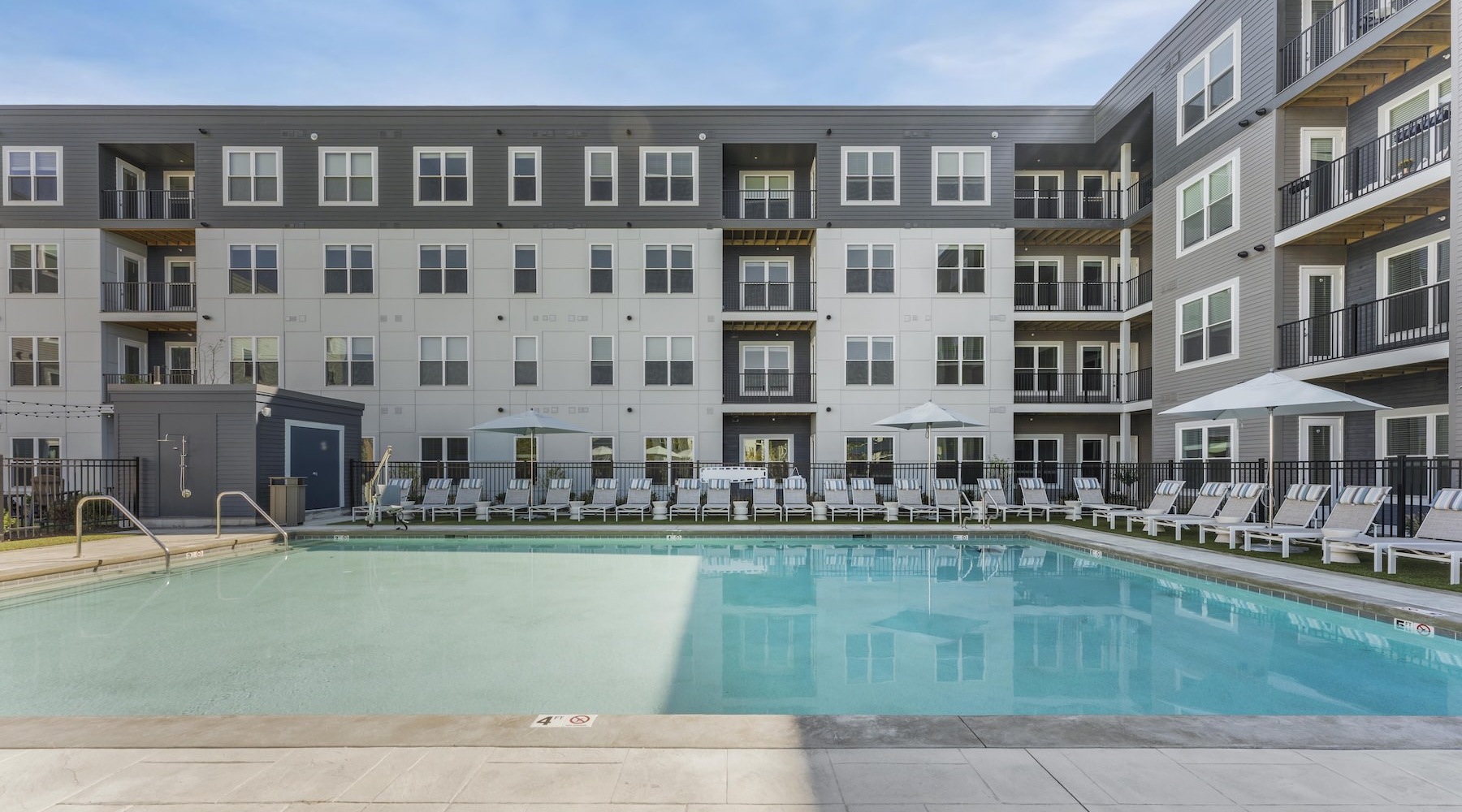 a pool with lounge chairs in a courtyard