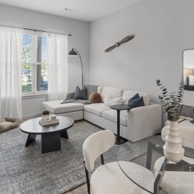 a living room with a couch, tables and chairs